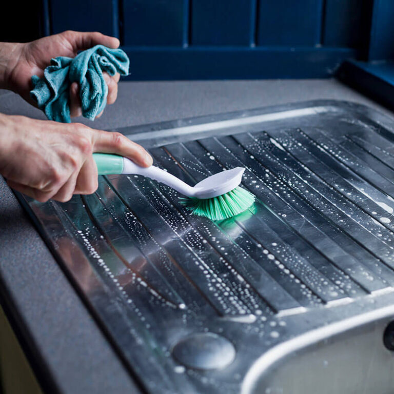 Scrubbing a greasy oven tray during kitchen deep cleaning in Qatar