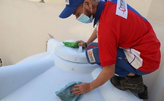 Emerald Qatar technician cleaning inside a water tank in Doha