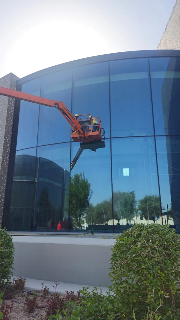 Exterior glass facade cleaning with boom lift in Qatar